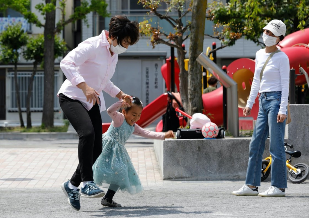 Shimada plays with her granddaughter Elisa, 4, as her daughter-in-law Tomoko, 44, looks on at a park.