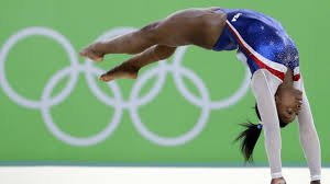 Biles performing gymnastics. 